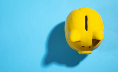 Mavi kağıtta sarı domuz kumbarası.