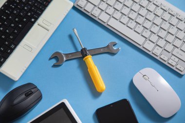 Bilgisayar klavyesi, akıllı telefonu, tableti, faresi olan bir anahtar ve tornavida. Bilgi İşlem. Destekle
