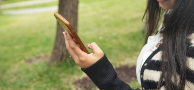 Dışarıda cep telefonu kullanan genç bir kadın..