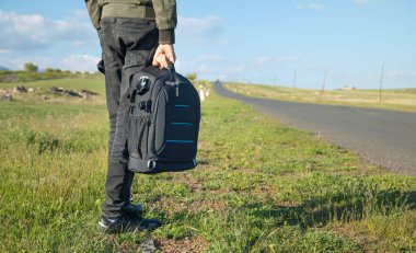 Sırt çantalı bir adam yolda duruyor..