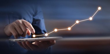 Büyüme grafiği olan dijital tablet kullanan adam.