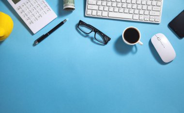 Para, kahve, hesap makinesi, mavi arka planda gözlük..