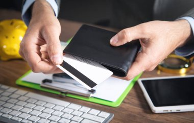 Kredi kartı ve cüzdan tutan adam..