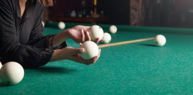 Masada bilardo toplarını tutan kadın..