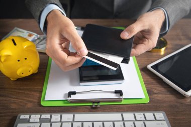 Kredi kartı ve cüzdan tutan adam..