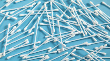 Mavi arka planda kulak temizleme için pamuk tomurcukları ya da çubuklar.