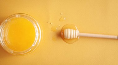 Sarı arkaplanlı bal kavanozu.