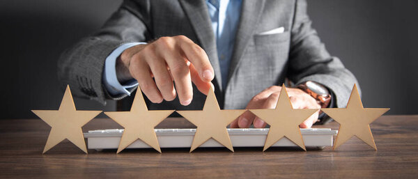 Male hand showing five star rating. 