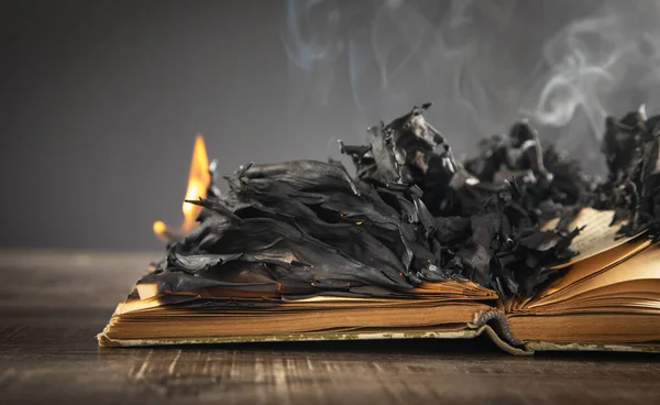 Burning book on the wooden table.