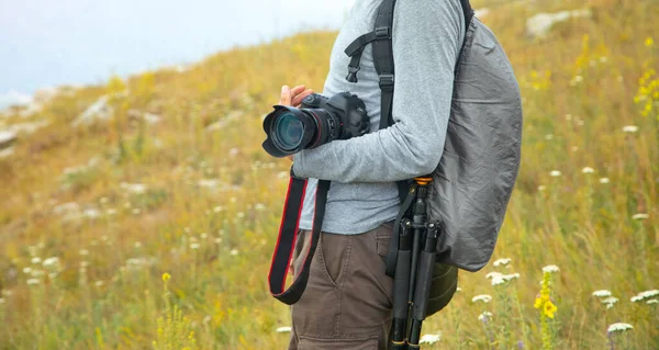 Photographer with backpack and digital camera in nature. Travel. Active lifestyle