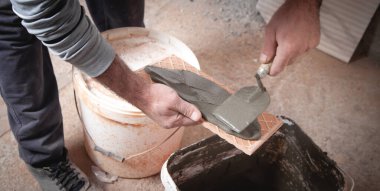 İşçi fayansa yapıştırıcı sürüyor.