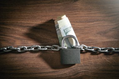 Dolar banknotları zincirler ve asma kilit ile kilitlenir.