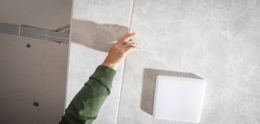 İnşaat işçisi asılmış tavanı monte ediyor.