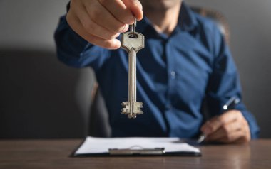 Anahtarları tutan ve kontratı imzalayan adam.