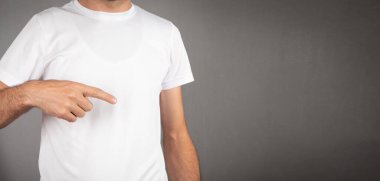  Gri arka planda beyaz tişörtlü bir adam..