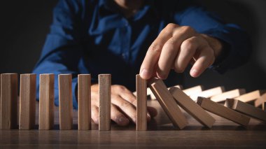 Erkek el çökmeyi durdurdu. Tahta blok dominosu. Risk ve Strateji