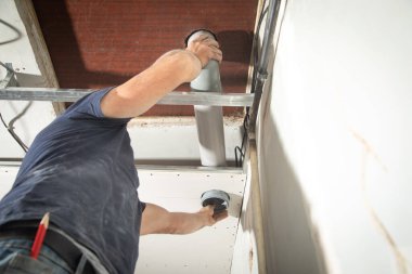 Evde plastik baca borusunu tamir eden bir işçi..