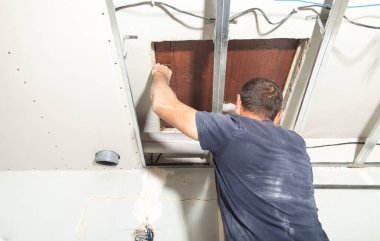 Evde plastik baca borusunu tamir eden bir işçi..