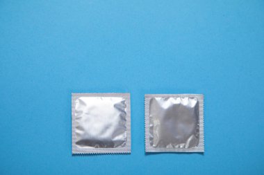 Mavi arka planda prezervatif. 
