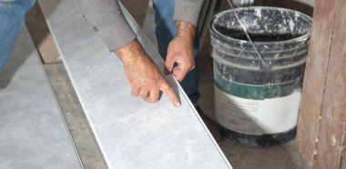 Plastik panel tutan bir işçi. Tavanı yeniliyorum.