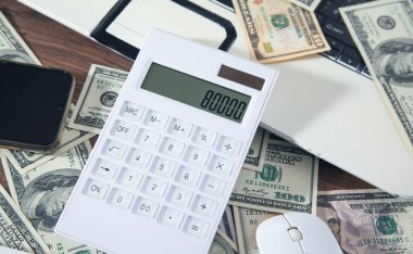 Bilgisayar faresi, hesap makinesi ve para bilgisayar klavyesinde.