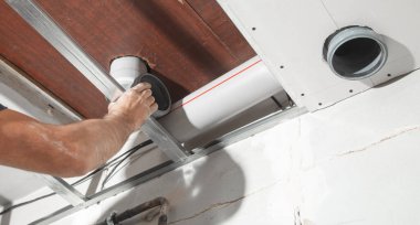 Evde plastik baca borusunu tamir eden bir işçi..