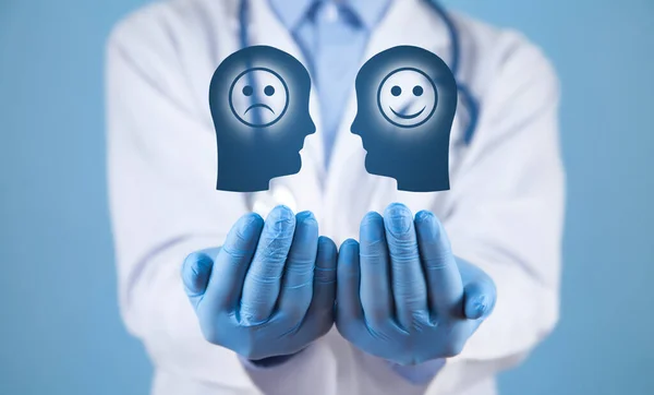Doctor showing human head with a sad and happy smiling face.