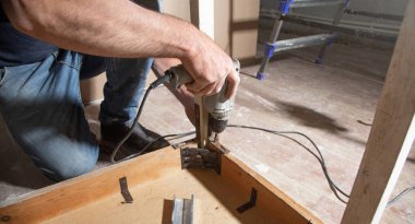 Kırık masayı tamir eden Kafkas marangoz.