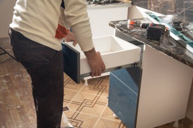 Yeni mutfak mobilyalarının işçiler montajı.