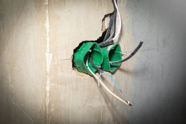 Soket deliklerinde kablo olan duvar. Soket kurulmadan önce hazırlama