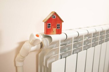 House model on the heating radiator. clipart