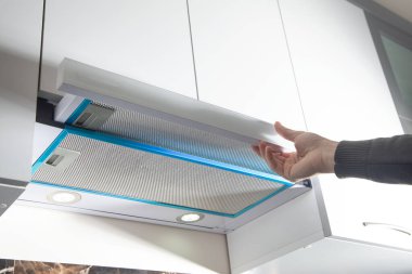 Modern mutfakta fırın başlığı kullanan bir erkek..