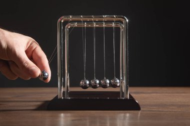 Erkek el Newton 'un beşik toplarını gösteriyor. İş dünyası
