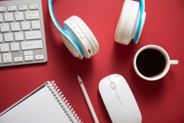 Bordo arka planında beyaz kablosuz kulaklık, kahve ve diğer nesneler var..