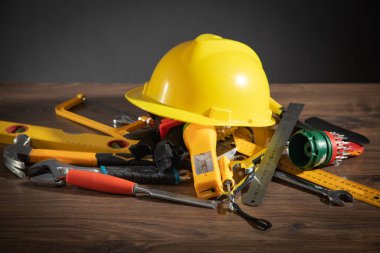 Ahşap arka planda miğferi olan çalışma araçları.