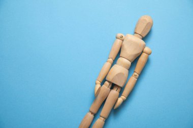 Mavi arka planda ahşap insan figürü.