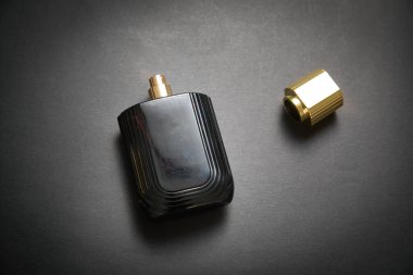 Siyah arka planda bir şişe parfüm..