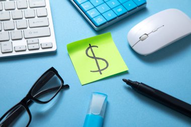 Hesap makinesi ve diğer nesnelerle birlikte yapışkan nottaki dolar sembolü iş. Finans