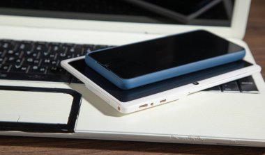 Ahşap masada akıllı telefon, tablet, dizüstü bilgisayar.