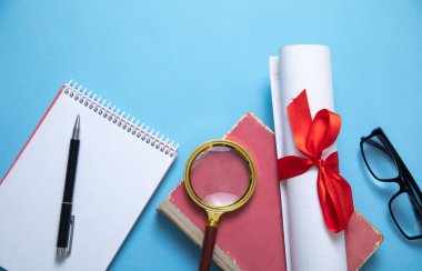 Mavi arkaplanda diploma ve iş objeleri.