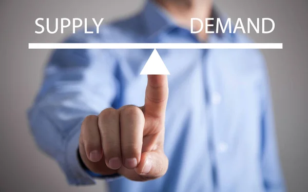 stock image Man showing supply and demand word balance scales. Business concept