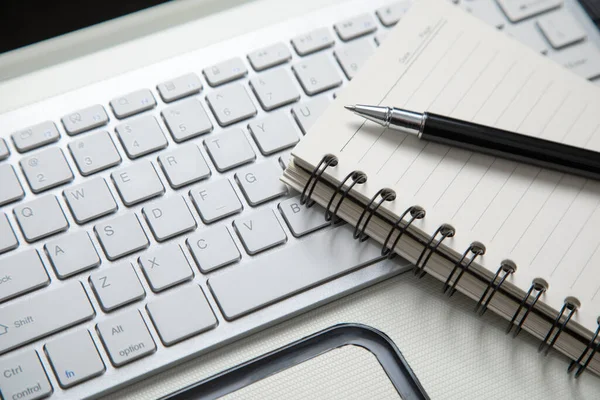 stock image Pen and notepad on the computer keyboard.