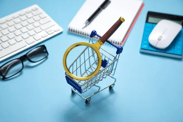 stock image Shopping cart with a computer keyboard and business objects.