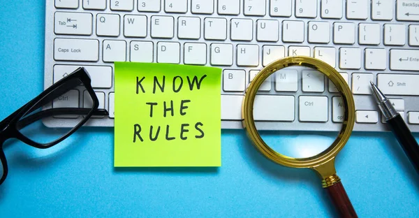 Know The Rules on sticky note with a business objects on the blue background.