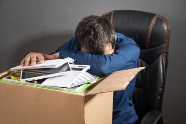 Elinde karton kutu ve iş eşyaları olan bir iş adamı. İş kaybı. İşsizlik Kurumu