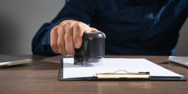 İşadamı ofisteki belgelere damga vuruyor..