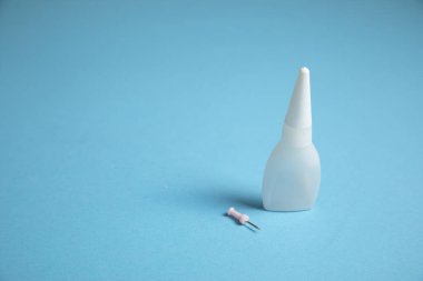 Mavi arka planda bir şişe yapıştırıcı..