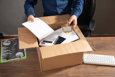 Elinde karton kutu ve iş eşyaları olan bir iş adamı. İş kaybı. İşsizlik Kurumu