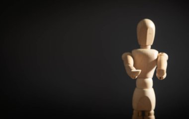 Gri arka planda tahtadan bir insan figürü.