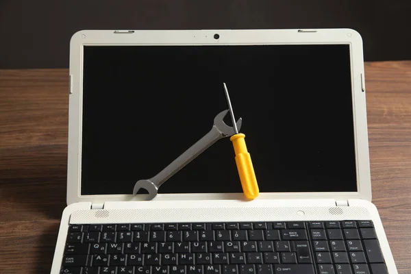 Wrench and screwdriver with a laptop computer. IT Service. Support